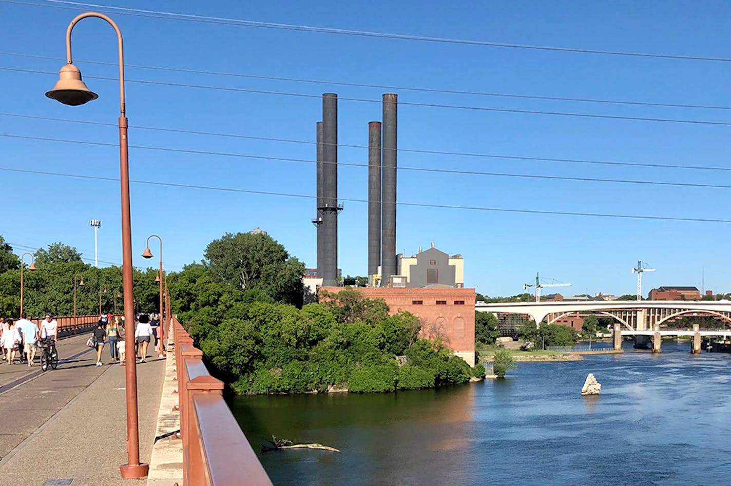 If you walk across the Stone Arch Bridge, you'll notice a massive stone pier jutting up from the Mississippi River near its eastern shore. If you look closely, you can spot the remains of a second pier marooned on land near the University of Minnesota's power plant off 6th Avenue SE. Those piers are all that remain of the first 10th Avenue bridge that once linked downtown Minneapolis and the eastern bank of the Mississippi.