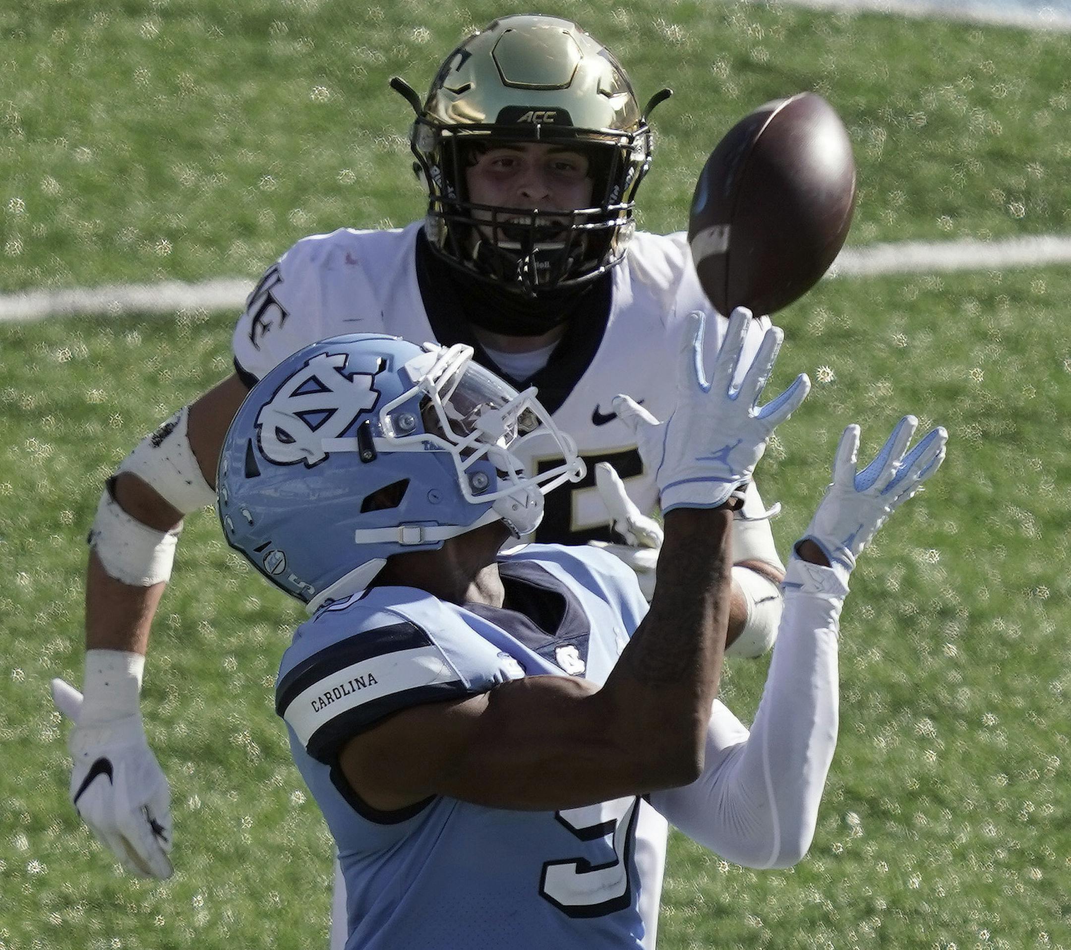 North Carolina wide receiver Dazz Newsome (5) catches a pass while Wake Forest defensive back Nick Andersen chases during the first half of an NCAA college football game in Chapel Hill, N.C., Saturday, Nov. 14, 2020. (AP Photo/Gerry Broome)