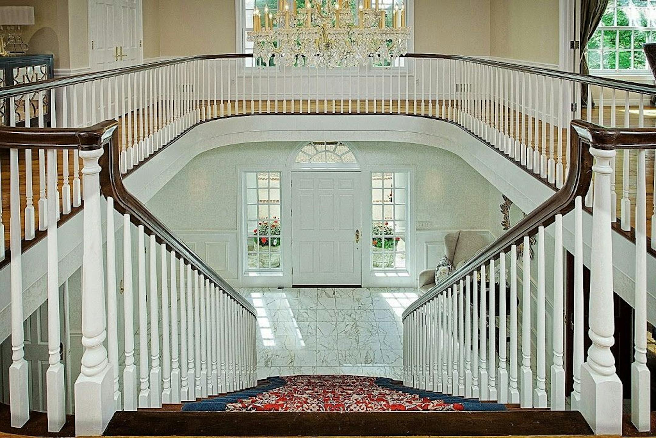 Two-story Italian marble foyer opens to a grand staircase and circular balcony