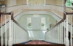 Two-story Italian marble foyer opens to a grand staircase and circular balcony