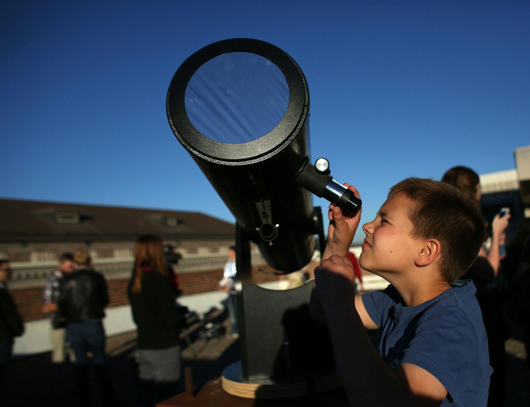 Nina Smith, of St. Paul, held up her daughter Thea, 4, so she could take a look at the partial solar eclipse through a telescope. ] (KYNDELL HARKNESS/STAR TRIBUNE) kyndell.harkness@startribune.com On the rooftop at the Tate Lab at the University of Minnesota in Minneapolis Min., Thursday, October 23, 2014.