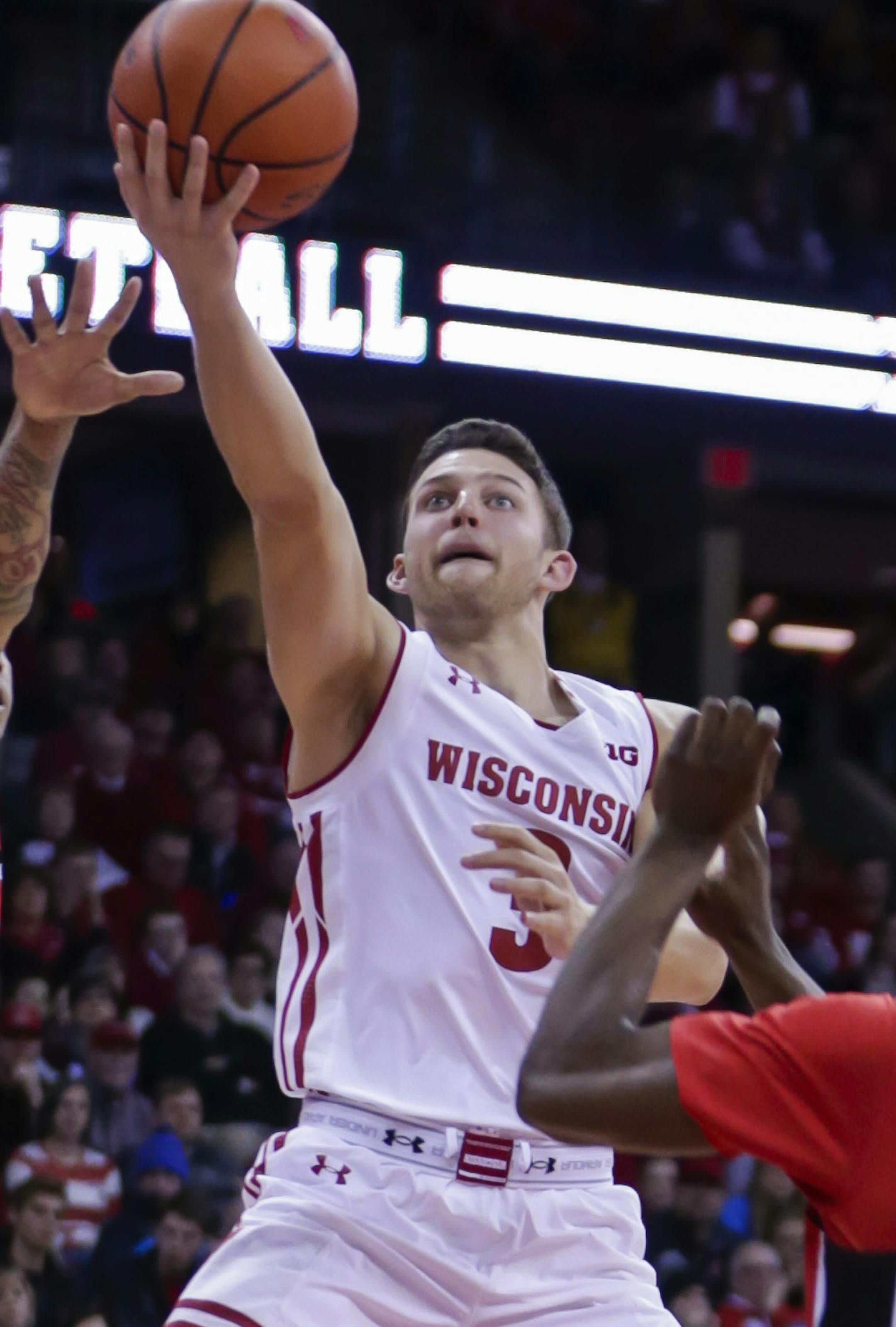 Wisconsin's Zak Showalter, center, shoots against Rutgers' Corey Sanders, left, and Mike Williams during the second half of an NCAA college basketball game Tuesday, Dec. 27, 2016, in Madison, Wis. Wisconsin won 72-52. (AP Photo/Andy Manis)