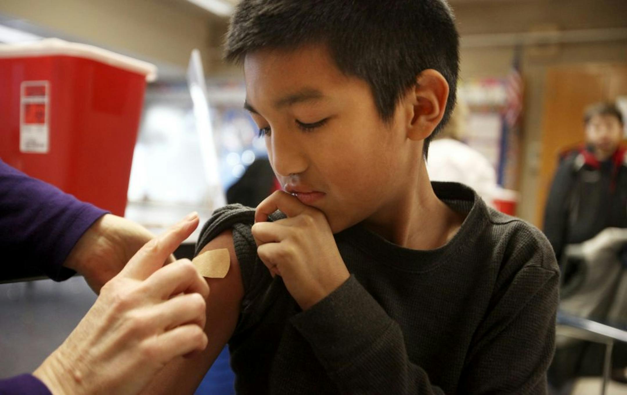 Jan. 12, 2013: Erick Perez, 9, of St. Louis Park, checked out his bandage after getting a flu shot from RN Renae Gronli during a flu clinic at Aquila Elementary School in St. Louis Park.