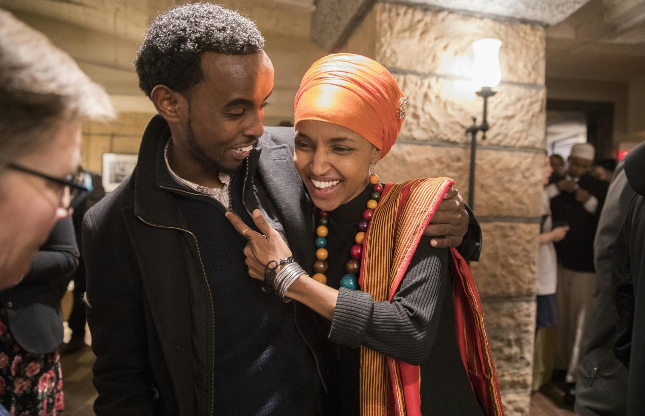 Rep. Ilhan Omar, DFL-Minneapolis, greets Ak Hassan, the chair of the DFL Somali Caucus, before her ceremonial swearing in.