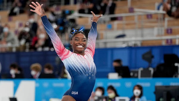 Simone Biles flashed a smile after completing her balance beam routine Tuesday at the Tokyo Olympics.