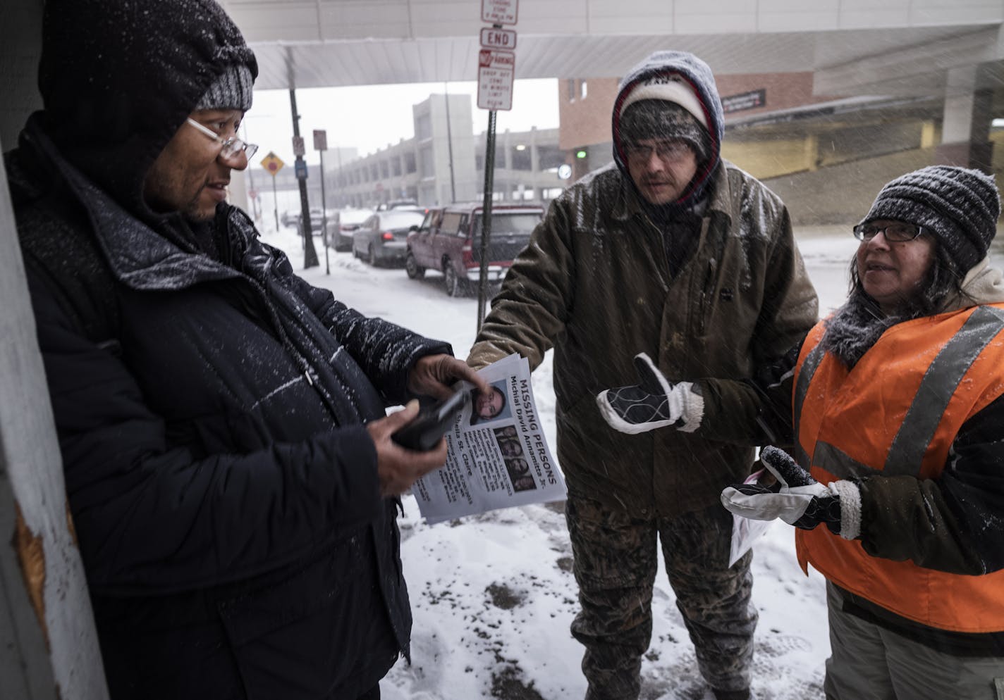 Ronald Carter accepted a flier from Jason Goward and Toni Branley about missing persons. Carter said he would hang the flier at his Duluth apartment complex.