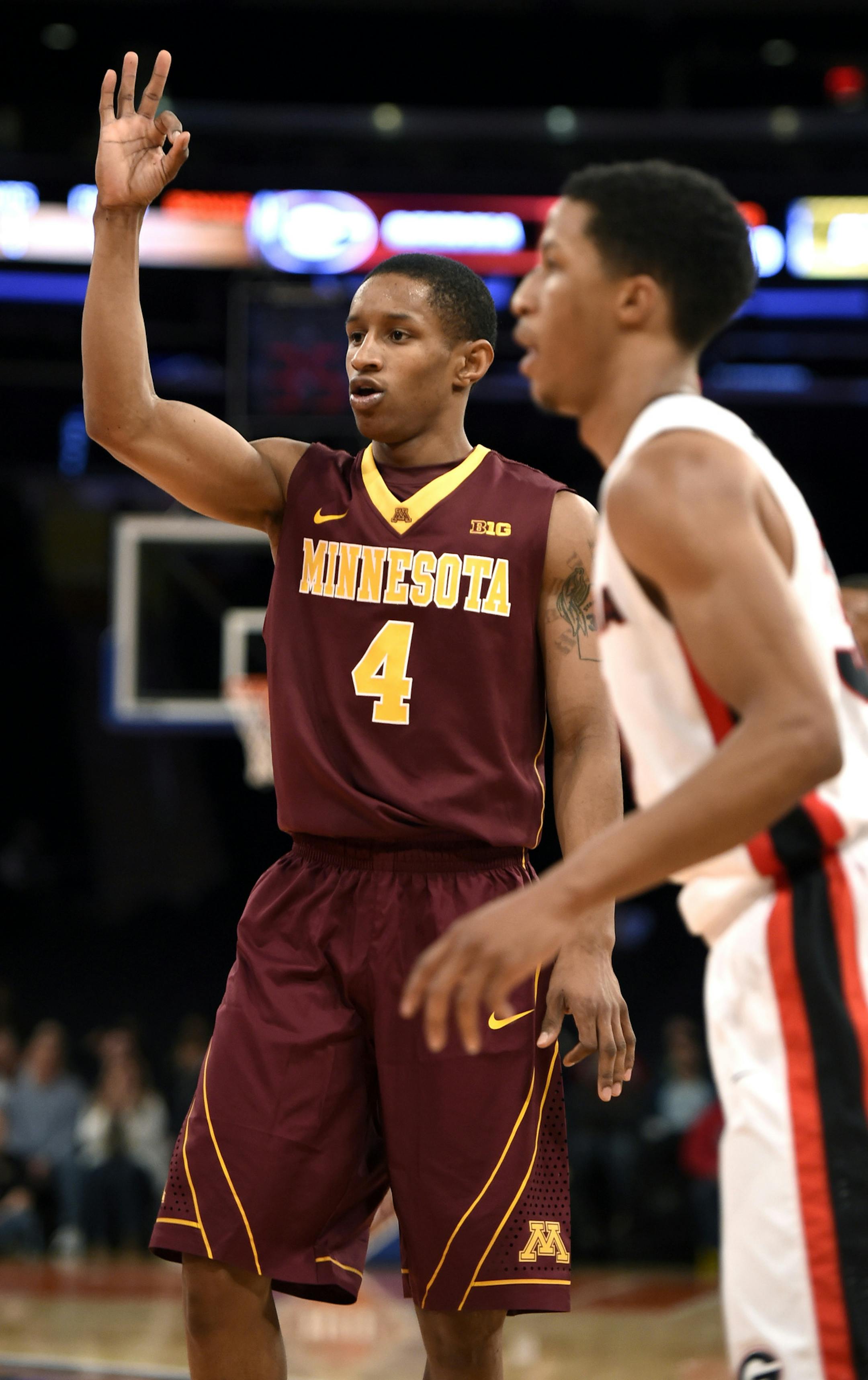 Minnesota's guard DeAndre Mathieu (4) hold three fingers in the air after hitting a three-point basket against Georgia in the second half of an NIT Season Tip-off consolation NCAA college basketball game at Madison Square Garden, Friday, Nov. 28, 2014, in New York. Minnesota won 66-62. (AP Photo/Kathy Kmonicek)