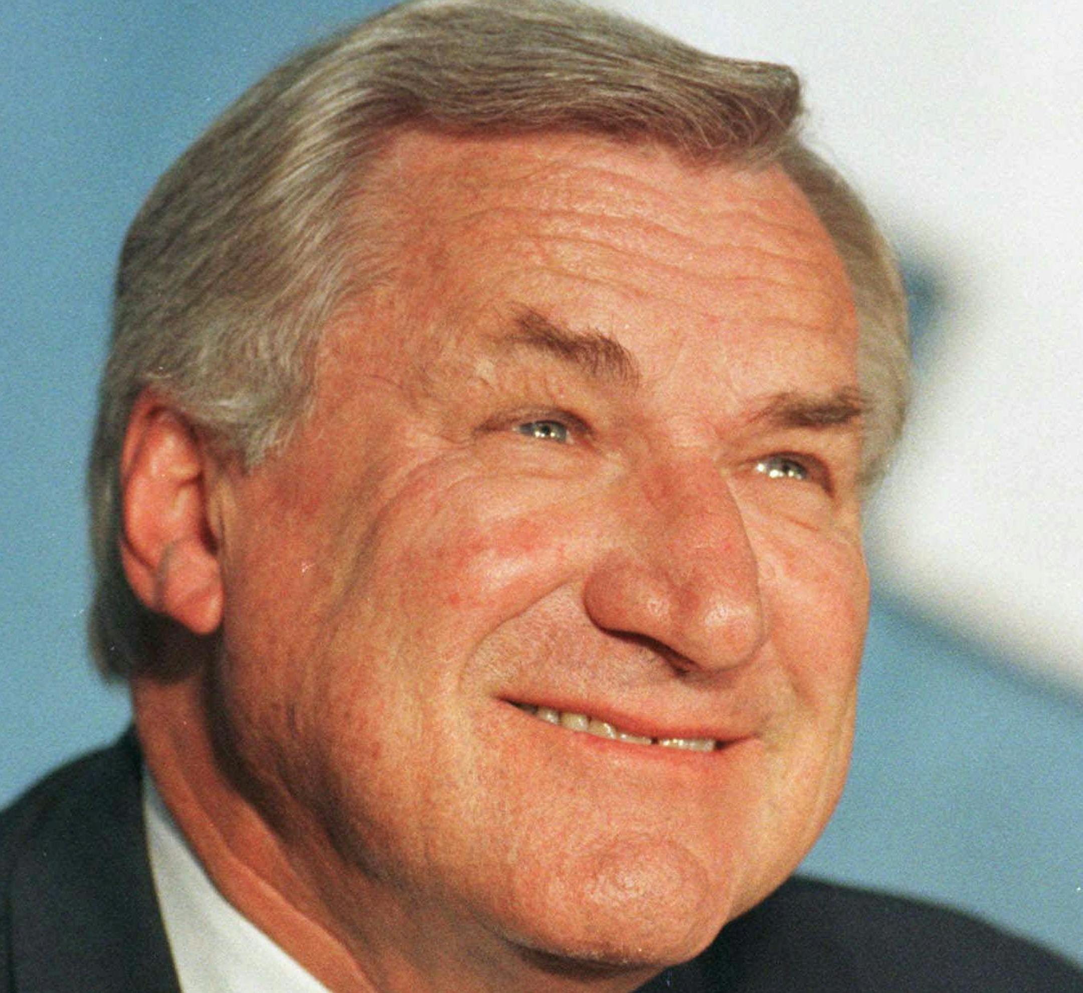 FILE - This Oct. 9, 1997, file photo shows North Carolina basketball coach Dean Smith during a news conference where he announced his retirement, in Chapel Hill, N.C. Dean Smith is still giving to his North Carolina players _ even after his death. Tim Breedlove, the Charlotte-based trustee of the trust that bears the late coach's name, said Thursday, March 26, 2015, that letters were sent earlier this month to each of the players who lettered for Smith's Tar Heel teams _ about 180 in all. The le