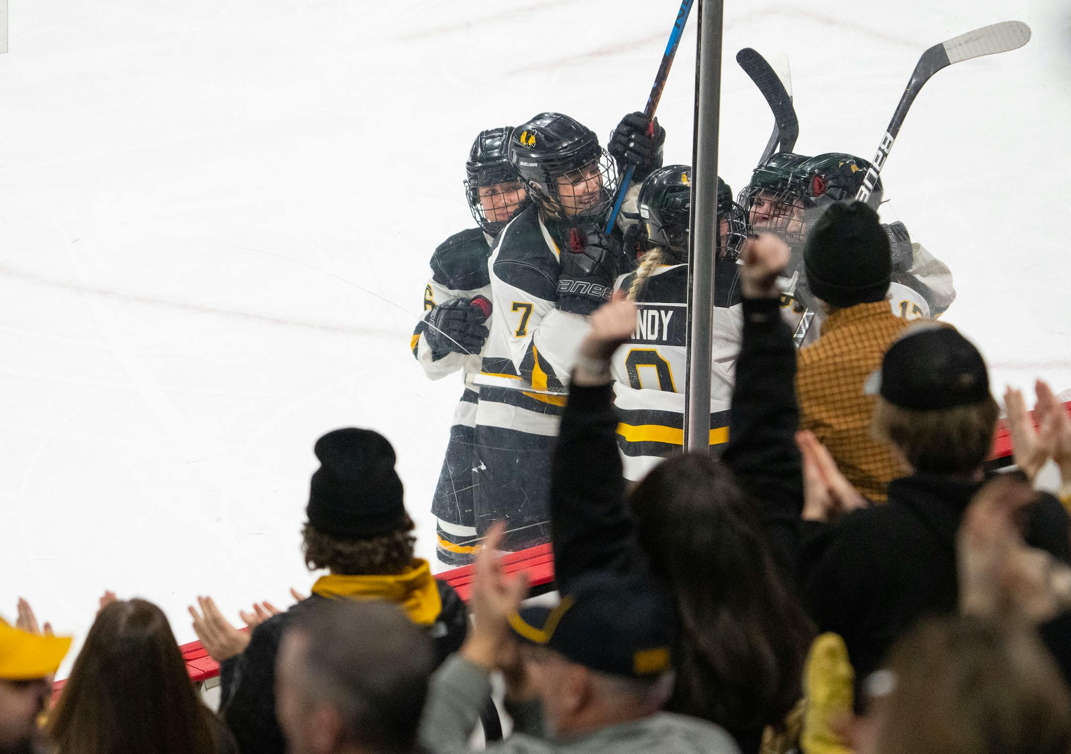 Warroad players swarm forward Kaiya Sandy (9) after she scored a goal against Orono in the second period.