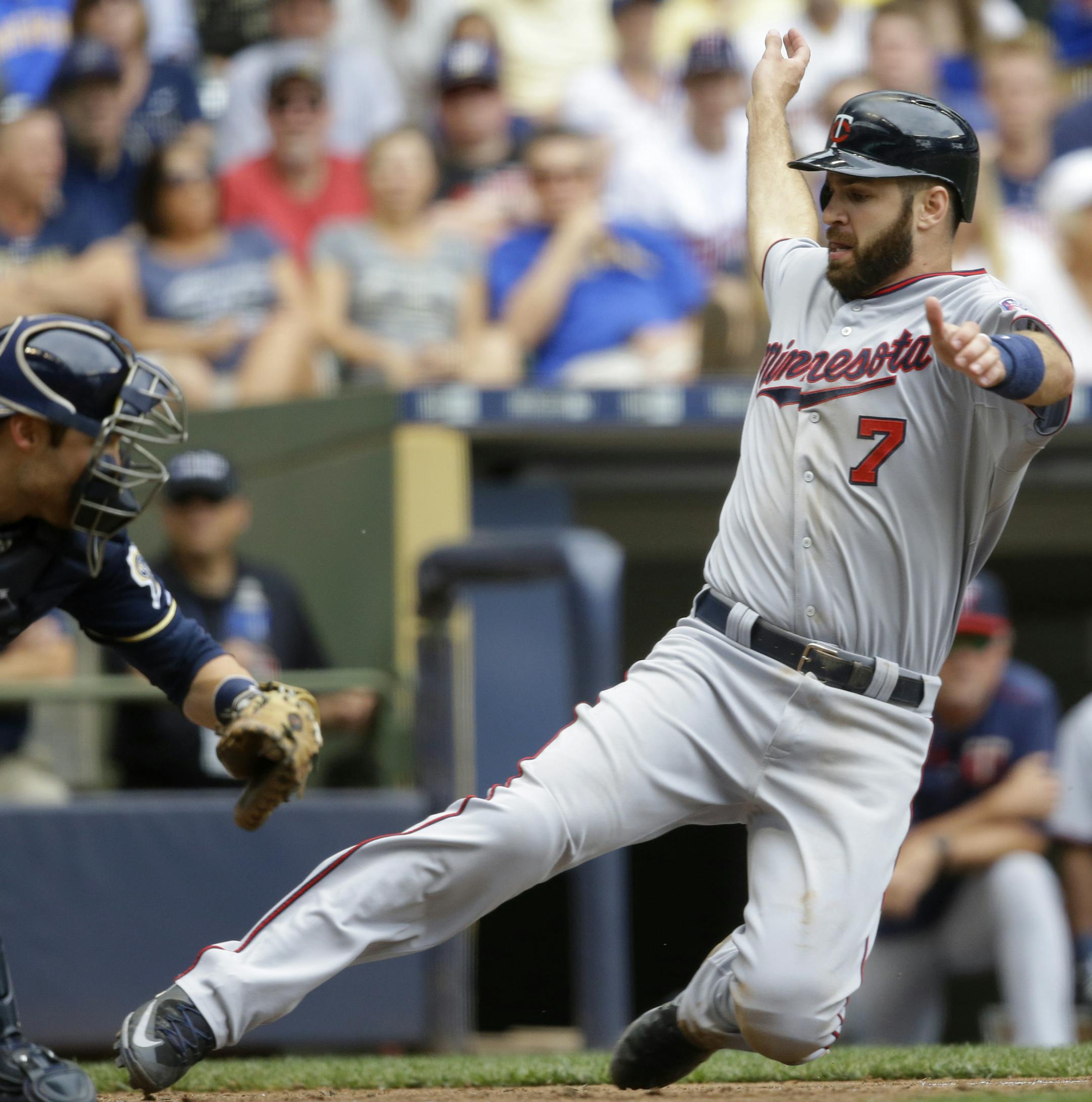 Minnesota Twins' Joe Mauer, right, scores ahead of the tag by Milwaukee Brewers catcher Jonathan Lucroy, left, during the seventh inning of a baseball game Sunday, June 28, 2015, in Milwaukee. (AP Photo/Jeffrey Phelps)