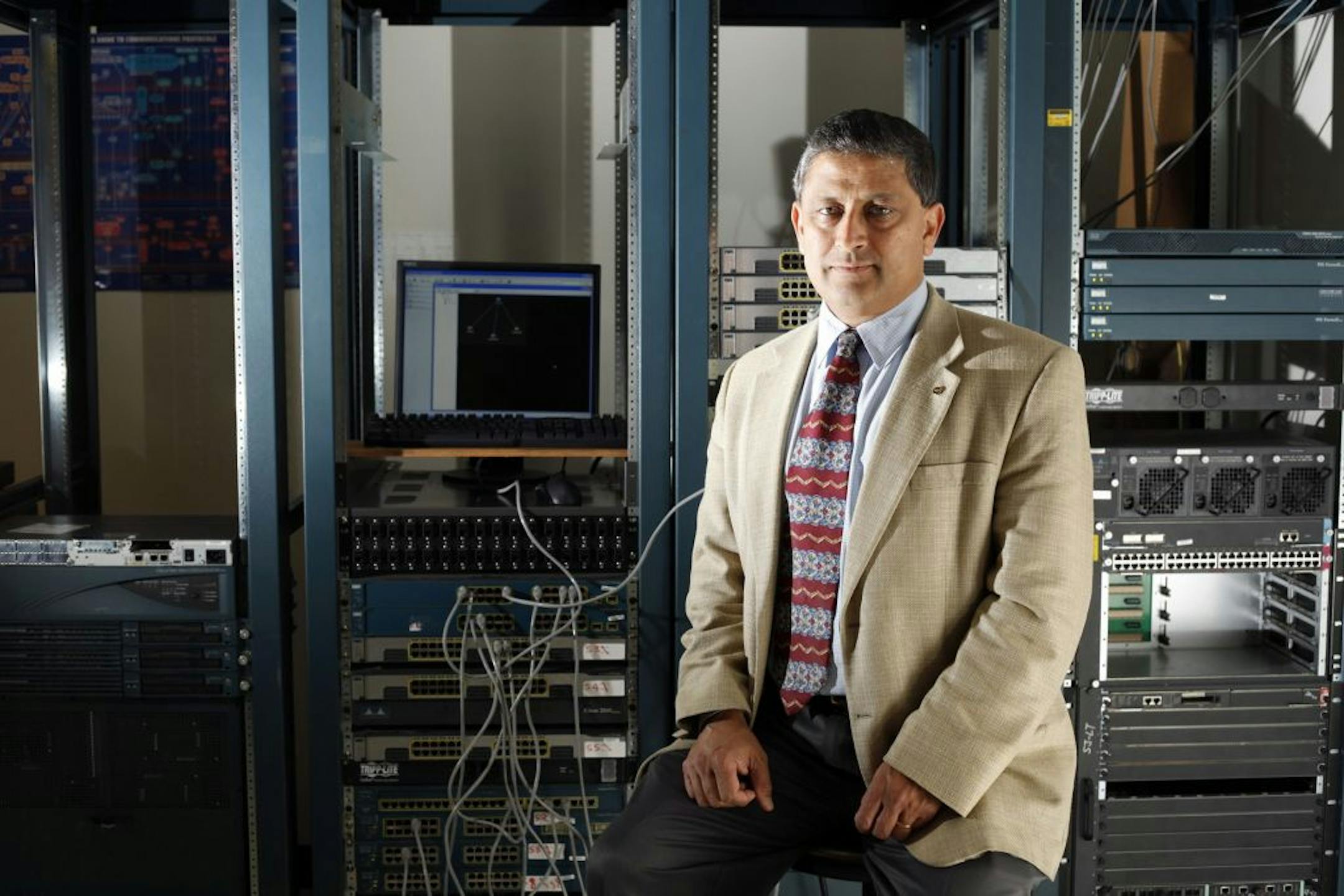 Ravi Pendse, a professor at Wichita State University, sits in front of routers and switches, the tools that make the Internet work, January 21, 2013, in Wichita, Kansas.