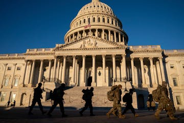 Members of the Army National Guard walk to board a bus after a shift at the Capitol Building in Washington, Jan. 10, 2021.