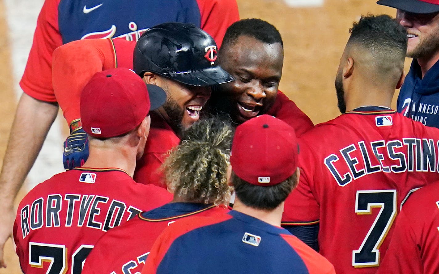 Miguel Sano, center hugs Nelson Cruz after Cruz's two-run home run off New York Yankees relief pitcher Aroldis Chapman during the ninth inning