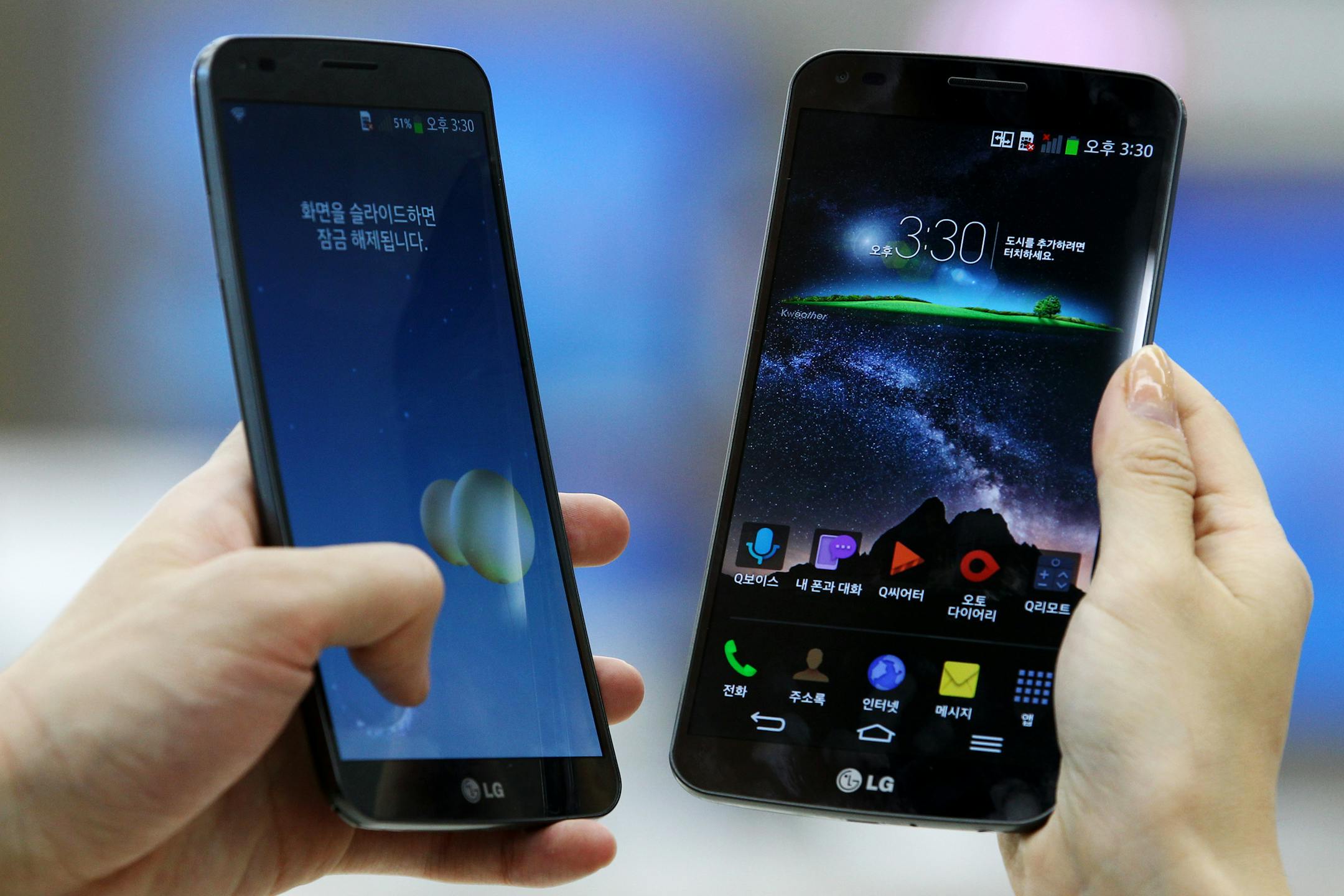 Employees demonstrate LG Electronics Inc. G Flex curved smartphones at the company's store in Seoul, South Korea, on Tuesday, Nov. 12, 2013. LG is the world�s third-largest smartphone maker. Photographer: SeongJoon Cho/Bloomberg