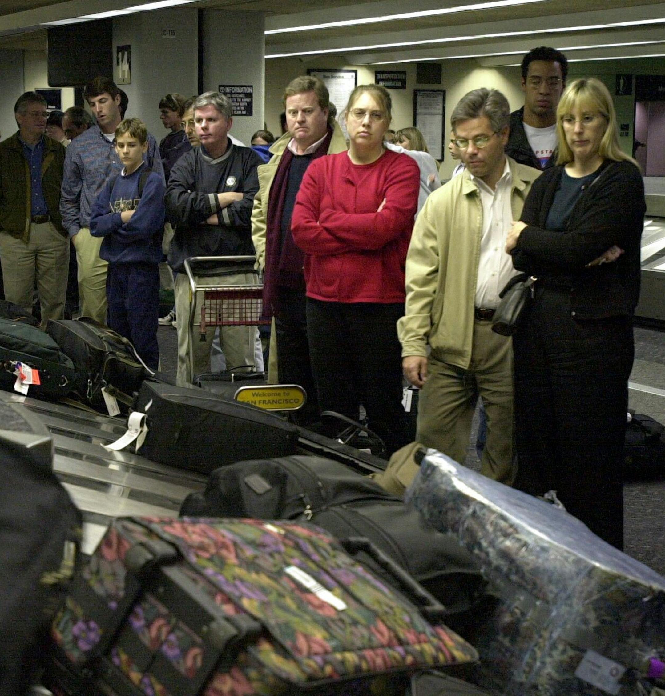 KRT TRAVEL STORY SLUGGED: LOSTLUGGAGE KRT PHOTOGRAPH BY BOB PEPPING/CONTRA COSTA TIMES (KRT111-February 14) There seems to be tension around the luggage carrousel as passengers wait for their bags to appear. People line up to grab their possessions after arriving at San Francisco International Airport. (CC) 2000 PL KD (Horiz) (mvw) ORG XMIT: KRT111