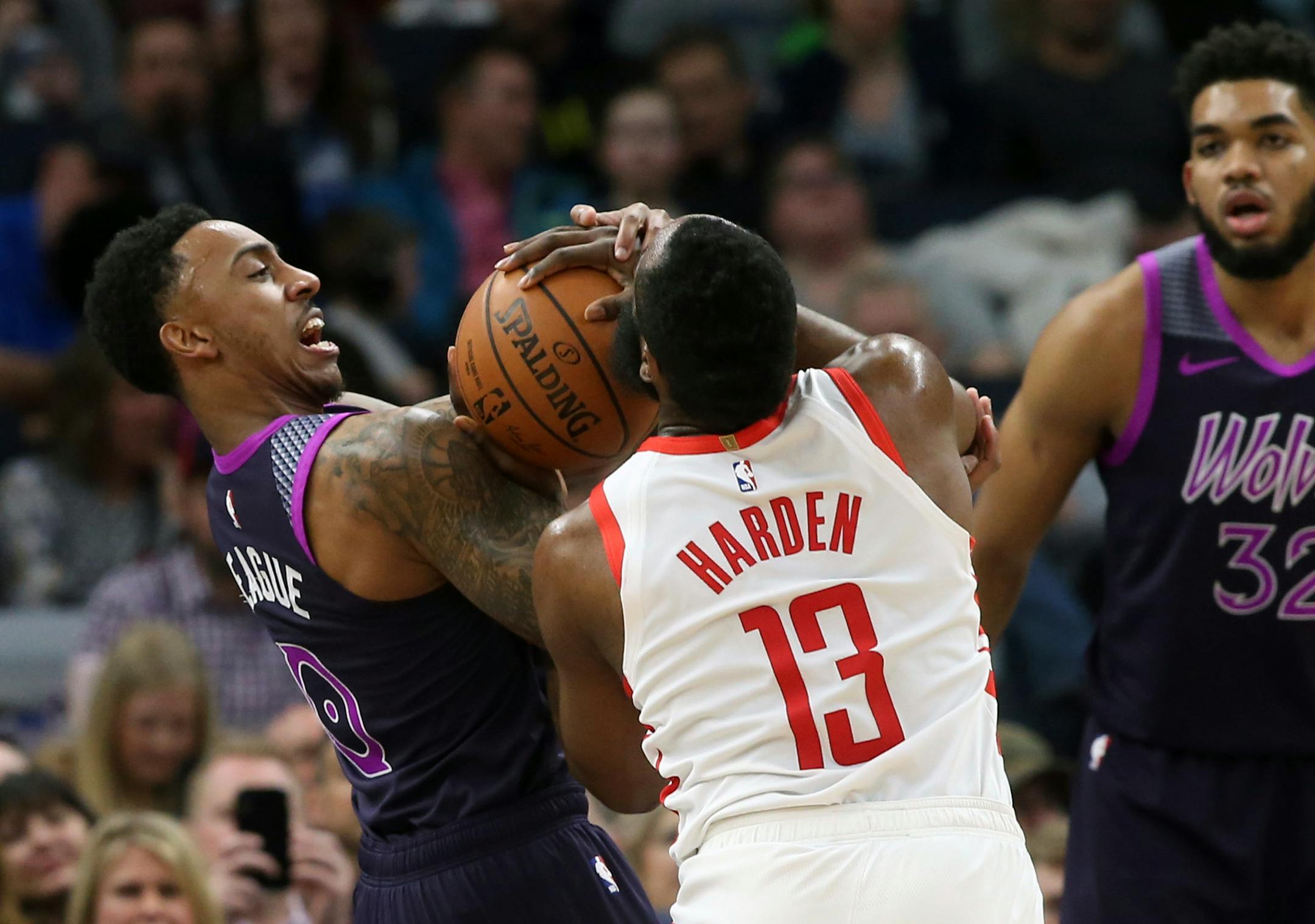 Houston's James Harden and Minnesota's Jeff Teague battle for the ball as Timberwolves' Karl-Anthony Towns looks on in the first half