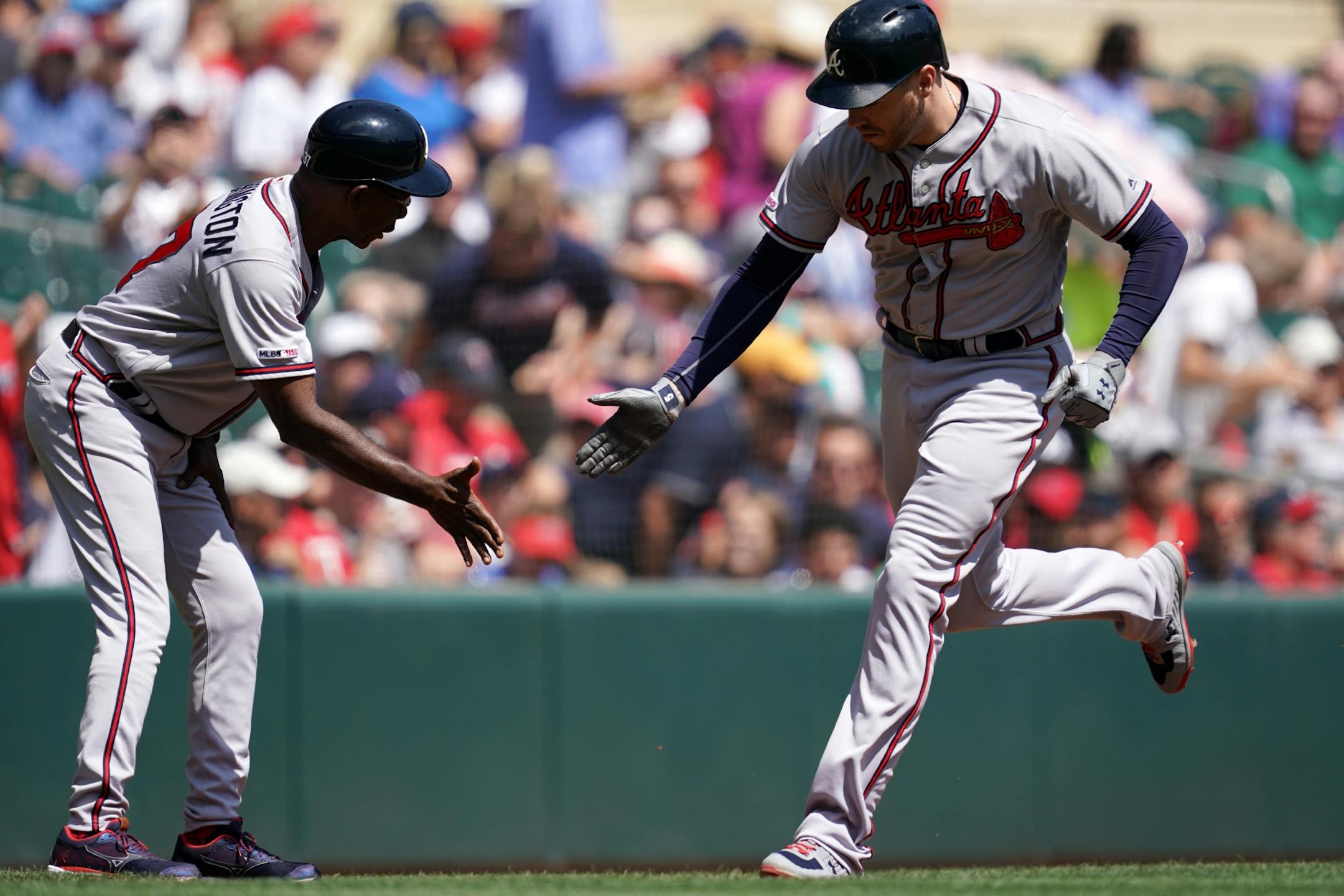 Atlanta Braves first baseman Freddie Freeman (5) was congratulated by Atlanta Braves third base coach Ron Washington (37) as he rounded third after hitting a solo home run in the first inning.