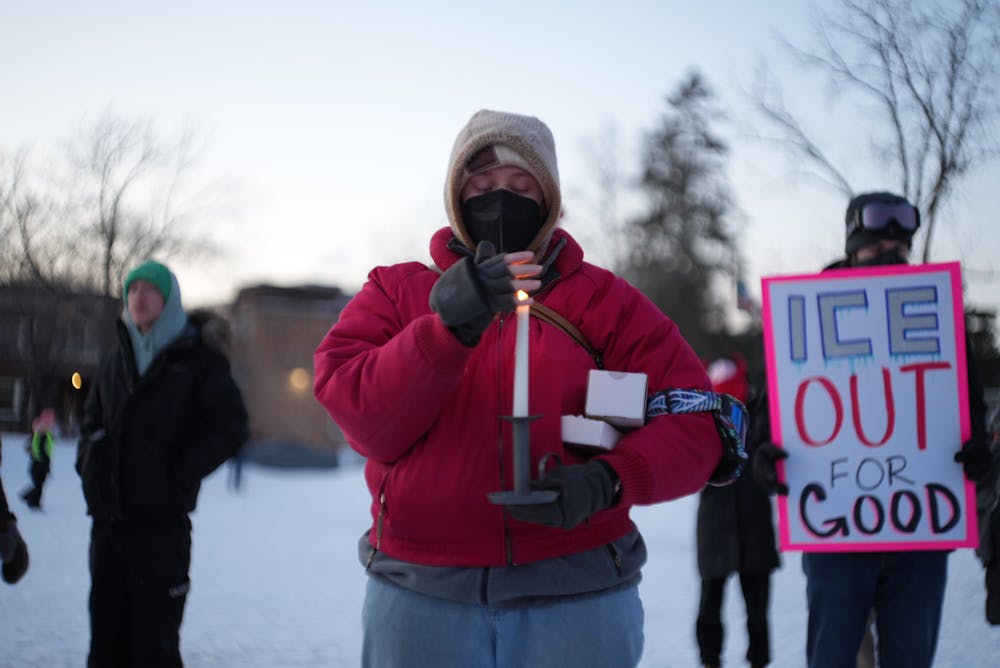 People gather for an early evening vigil in Whittier Park and light candles for Alex Pretti who was fatally shot by federal agents in South Minneapolis.