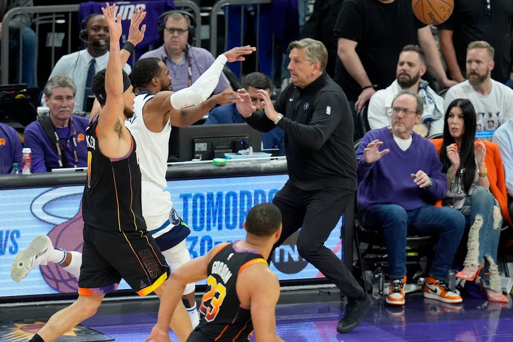 Wolves coach Chris Finch, right, tries to avoid point guard Mike Conley after Conley was fouled by Suns guard Devin Booker.