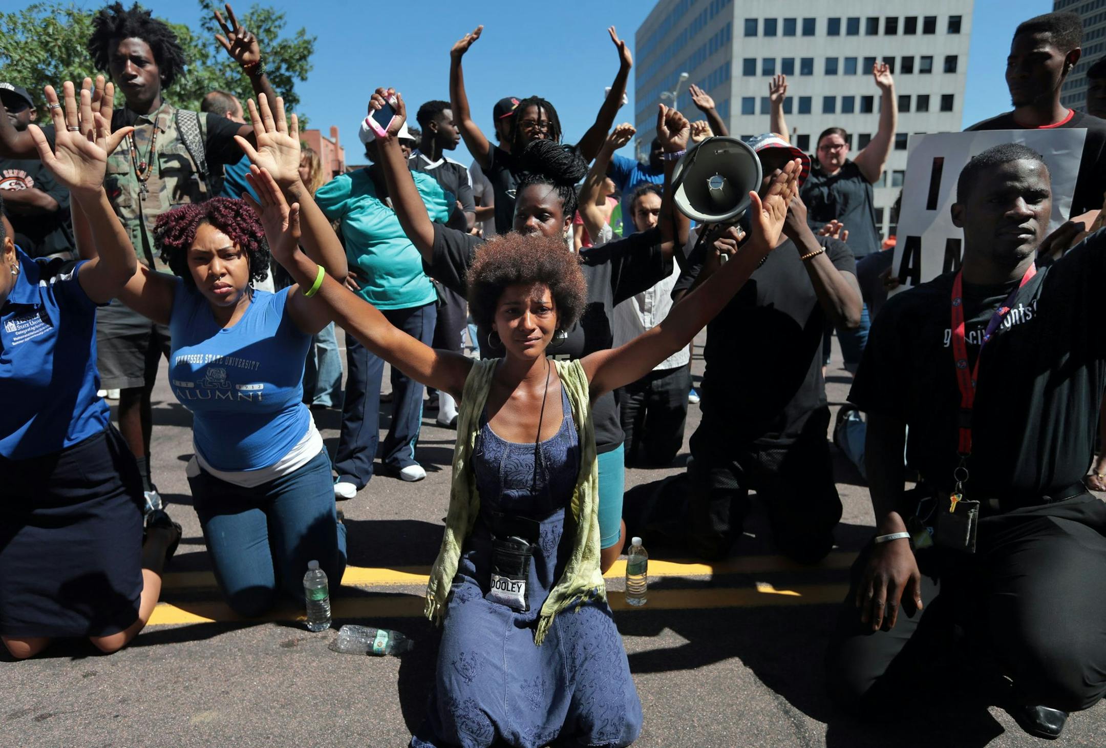 Protestors drop to their knees and put their arms in the air during a rally for Michael Brown Jr., who was shot and killed by a Ferguson police officer last Saturday, Tuesday, Aug. 12, 2014, in Clayton, Mo. (AP Photo/St. Louis Post-Dispatch, Laurie Skrivan)