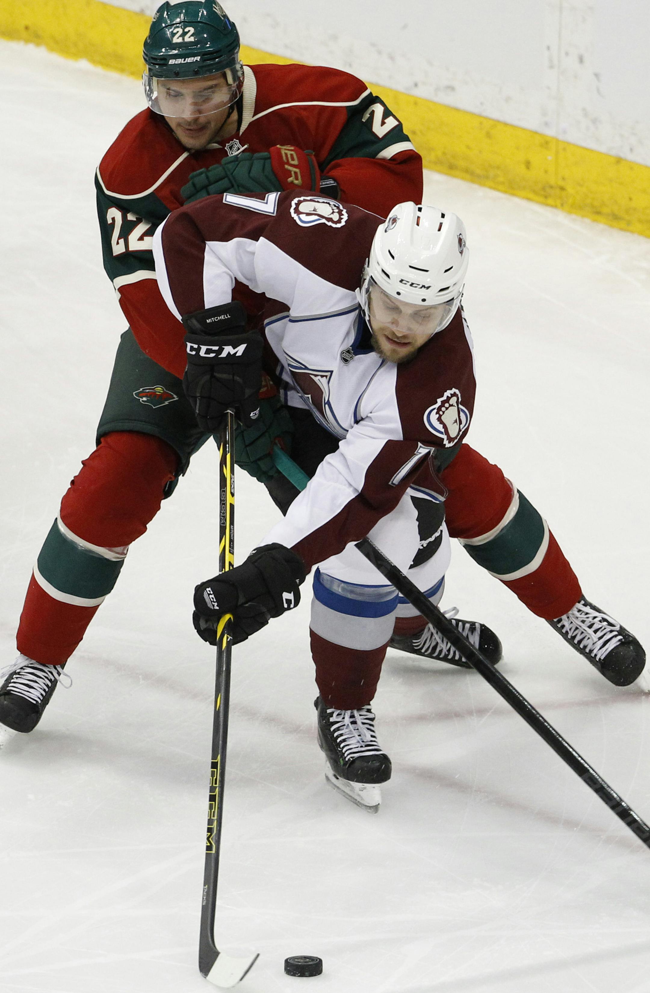 Colorado Avalanche center John Mitchell, front, and Minnesota Wild right wing Nino Niederreiter (22), of Switzerland, chase the puck during the first period of an NHL hockey game in St. Paul, Minn., Saturday, Feb. 7, 2015. (AP Photo/Ann Heisenfelt)