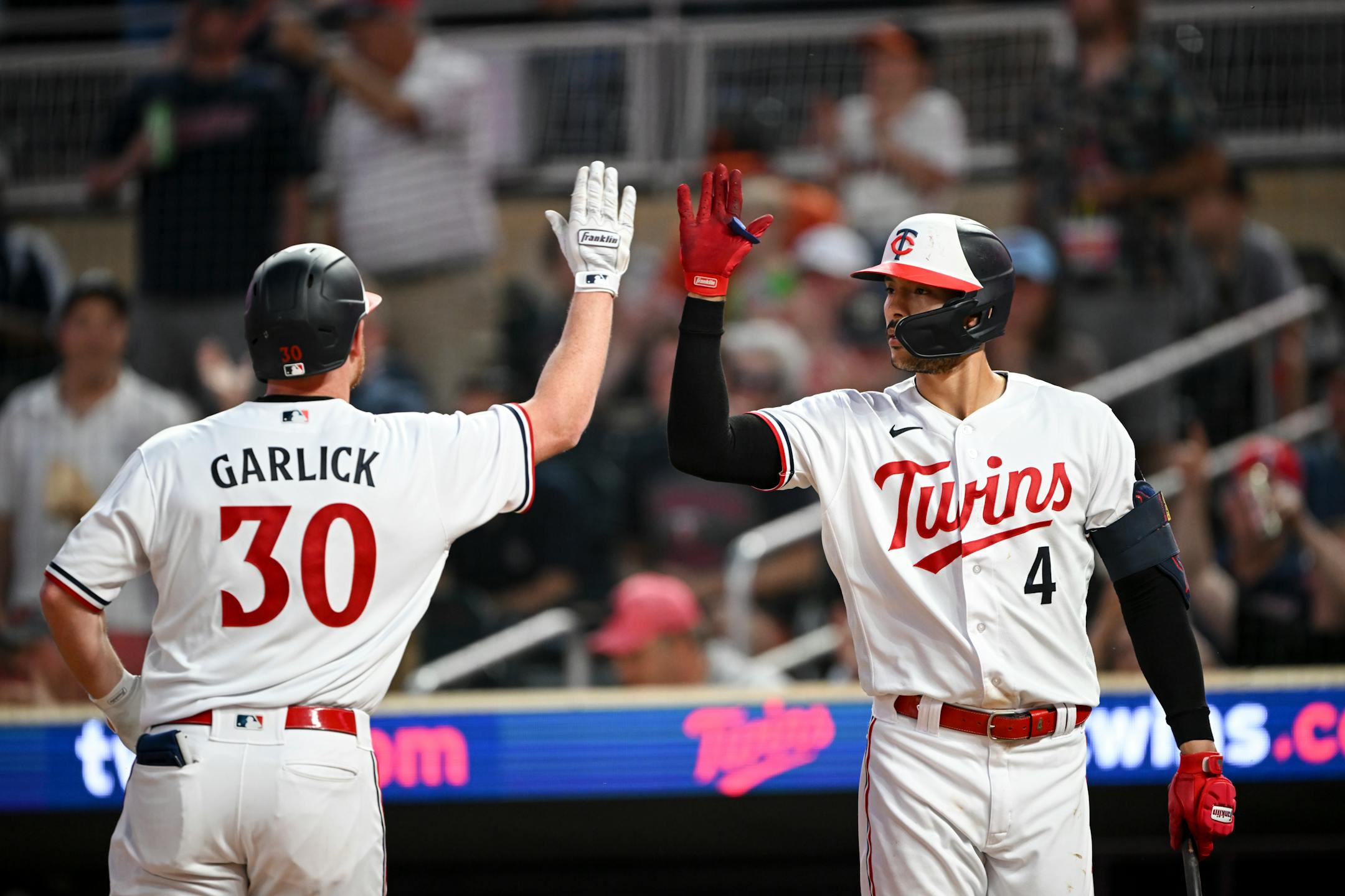 Minnesota Twins left fielder Kyle Garlick and shortstop Carlos Correa celebrate a solo home run hit by Garlick in the bottom of the eighth inning.