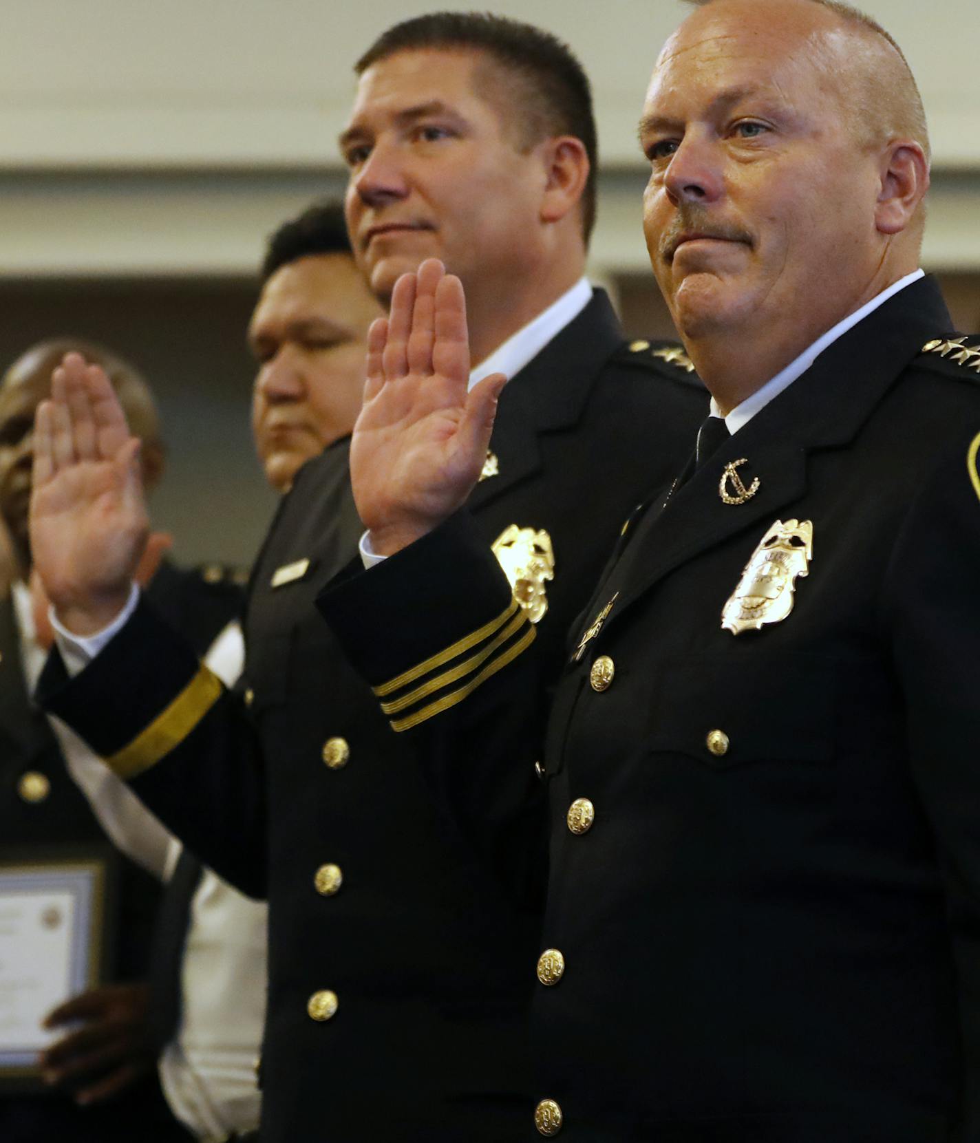 Newly promoted assistant chief Michael Kjos, far right, took an oath to serve his duties.] The MPD will recognize 20 recently-promoted sergeants, lieutenants, commands, etc. at a ceremony Monday afternoon in south Minneapolis. This will also be Medaria Arradondo's first promotions ceremony as chief. Richard Tsong-Taatarii/Richard.tsong-taatarii@startribune.com