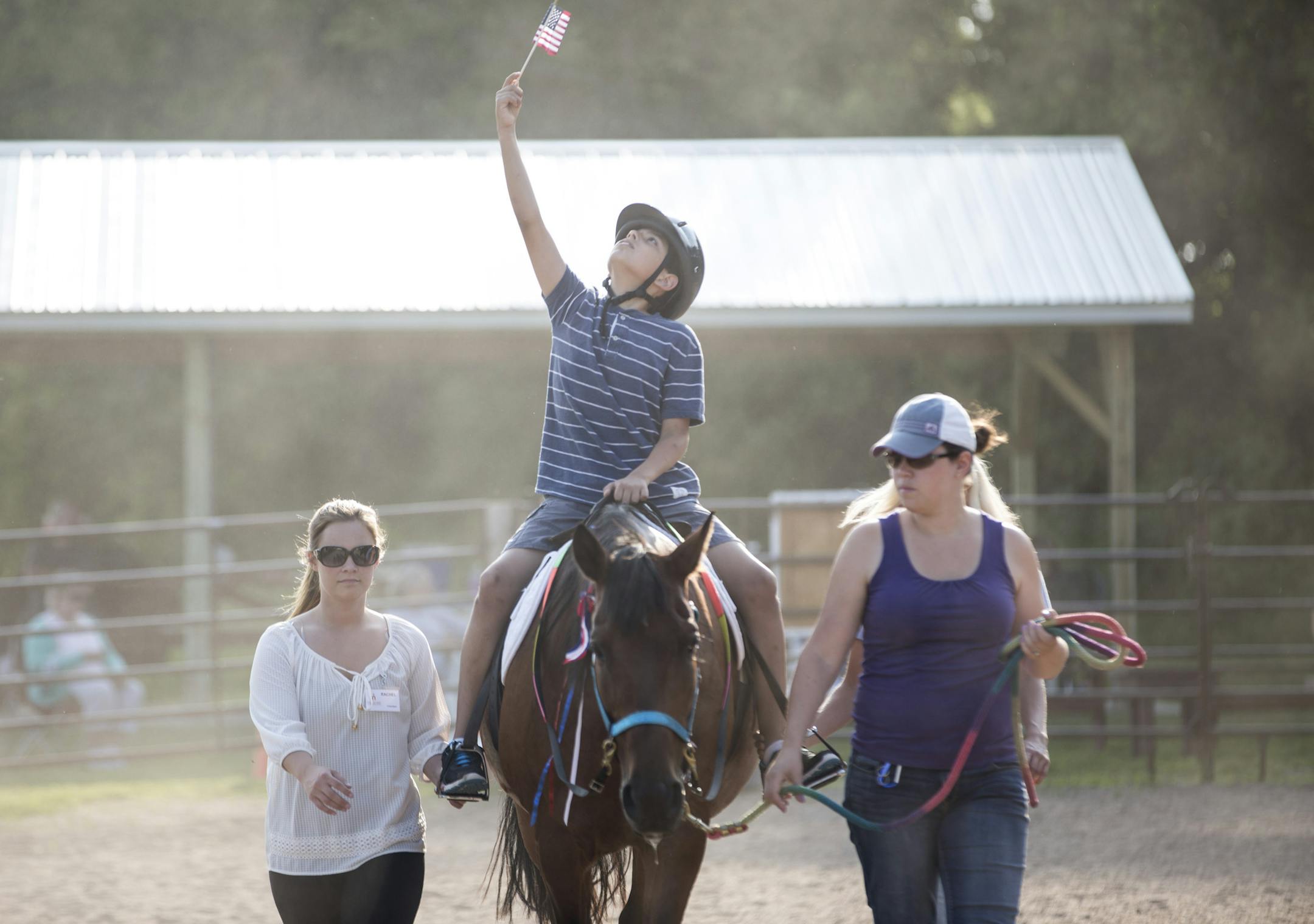Ignacio Bonifaz held up a flag during a patriotic procession on Gorgeous. With him were volunteers Rachel NcNeil, left, and Kristen Berghoff.
