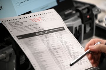 An election judge looked over a blank test ballot at the Elections and Voter Services Office in Minneapolis.