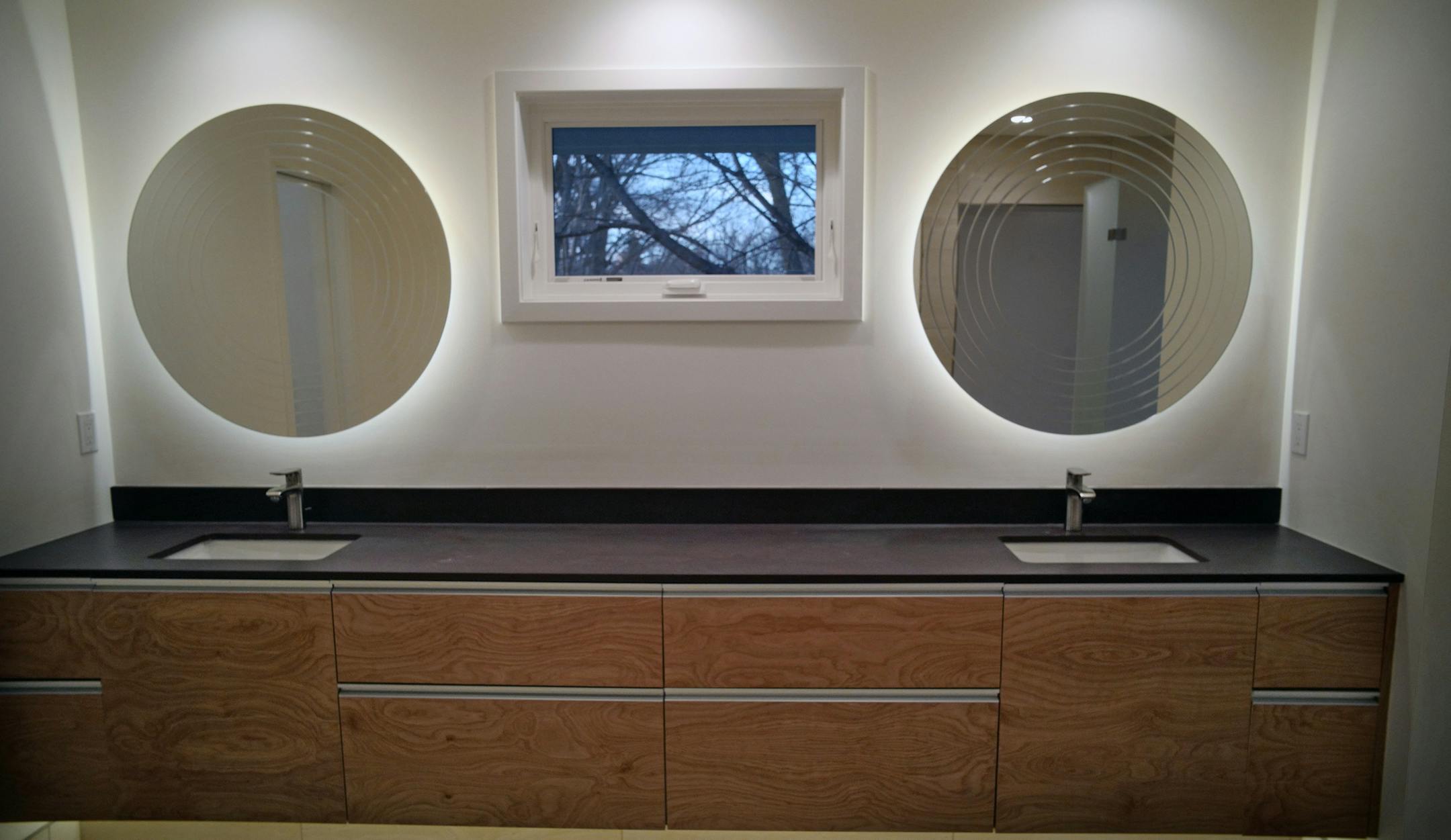 Back-lit circular mirrors in the owners' bathroom