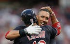 The Cleveland Indians’ Francisco Lindor hugs teammate Michael Brantley after Brantley hit a double to score Lindor for a 2-1 win in 10 innings again
