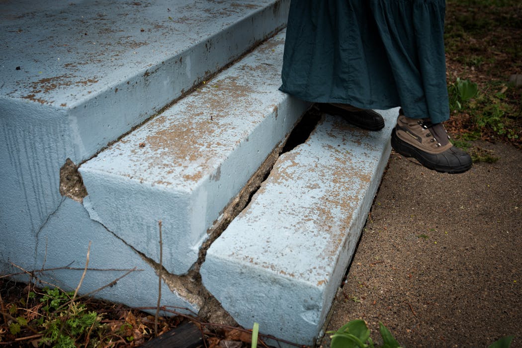 Giovanna Johnson’s cracked front steps have been sinking since 2011. They need to be replaced due to frequent flooding.