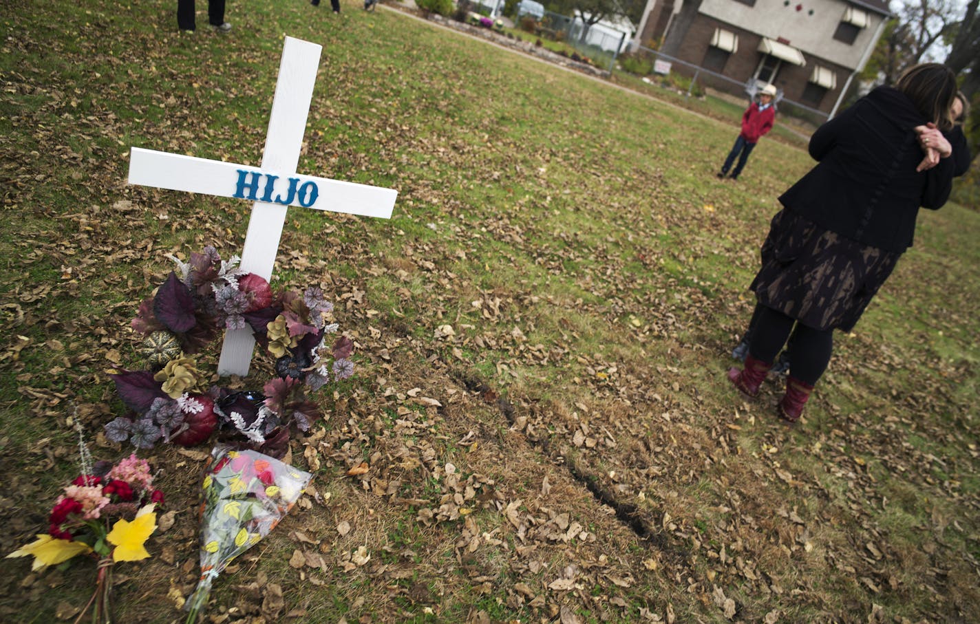 Near the intersection of Knox Ave. and Memorial Parkway, neighborhood residents Sarah Goldammer and Rachel Kurtz hugged. Kurtz brought a homemade cross and a wreath to remember a five-year old boy was killed while trick or treating on Halloween.