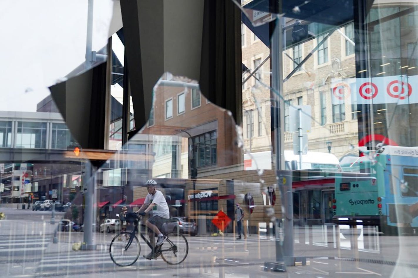 A man surveyed the damage as he rode his bicycle down Nicollet Mall where several businesses were damaged by a group of looters Wednesday night after the suicide of a homicide suspect on the Mall ignited rioting.