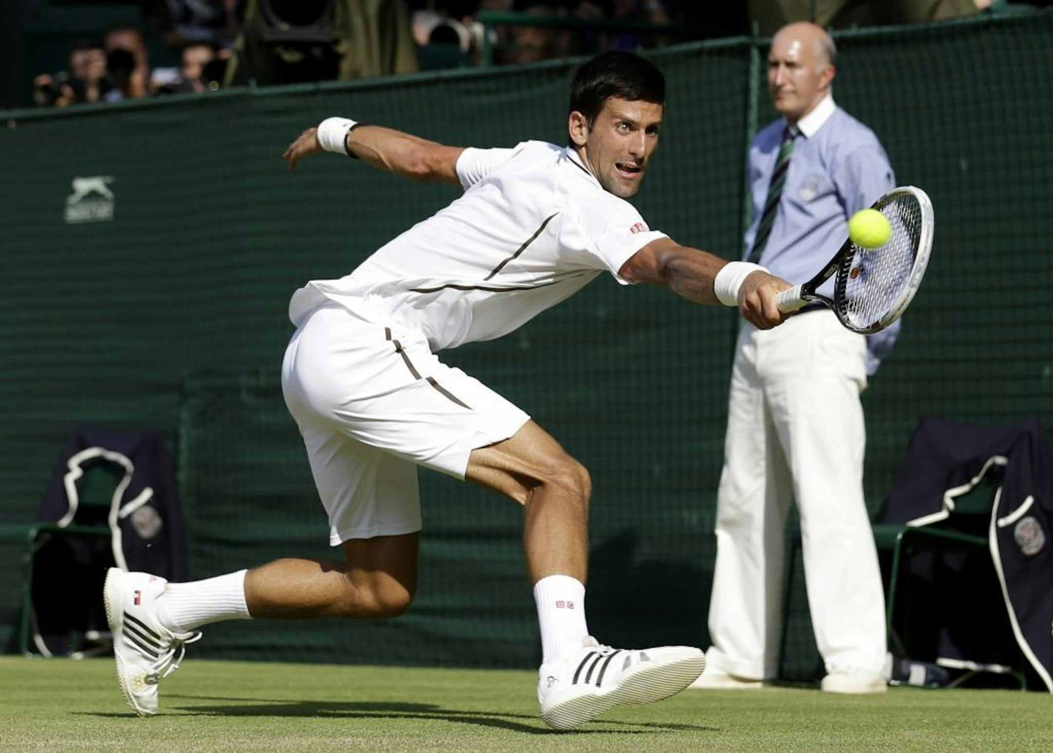 Novak Djokovic of Serbia plays a return to Andy Murray of Britain during the Men's singles final match at the All England Lawn Tennis Championships in Wimbledon, London, Sunday, July 7, 2013.