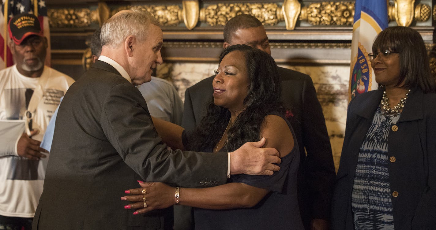 Minnesota Gov. Mark Dayton, left, embracee Valerie Castile after announcing that $12 million in funding for the "Philando Castile Law Enforcement Training Fund," one year after Castile was killed, on Thursday, July 6, in St. Paul, Minn. (Jerry Holt/Minneapolis Star Tribune/TNS) ORG XMIT: 1205770 ORG XMIT: MIN1707061949172651