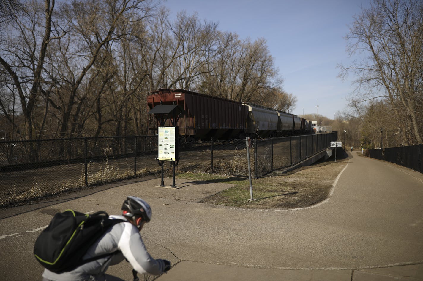 A cyclist on the Greenway bike path alongside a train on the approach to the Short Line bridge Wednesday afternoon. ] JEFF WHEELER &#x2022; jeff.wheeler@startribune.com There are discussions taking place about exploring whether the CM & StP Railroad's Short Line bridge over the Mississippi River at the Midtown Greenway could be overhauled for bike and pedestrian use. The Greenway / railroad corridor was photographed Wednesday afternoon, April 25, 2018 in Minneapolis.