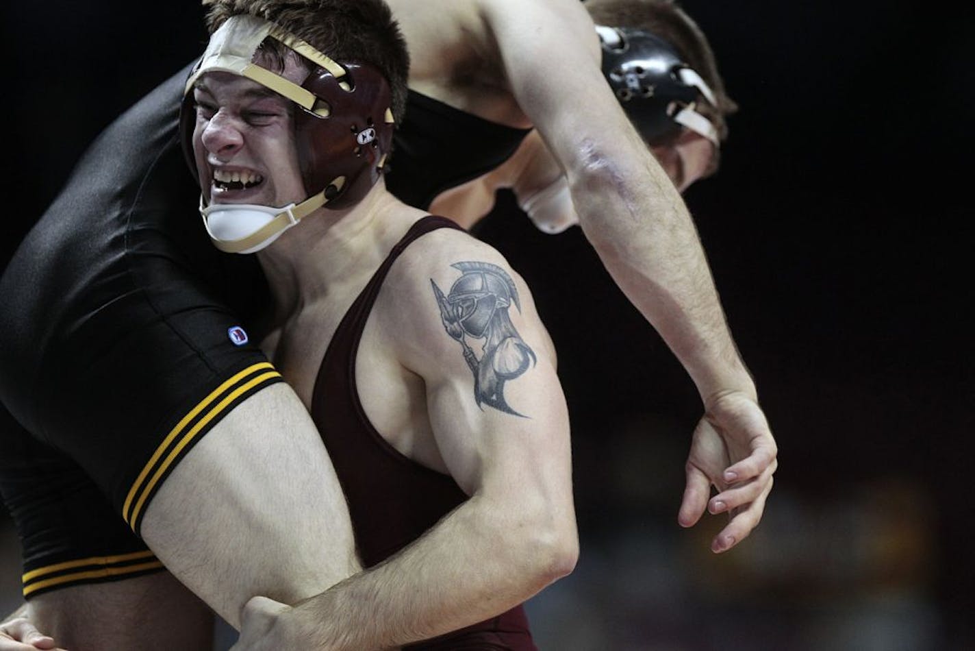 Minnesota's Nick Dardanes (facing camera) lifted Iowa's Mark Ballweg in the air during a victory in the 141lb match in the National Duals semifinals.