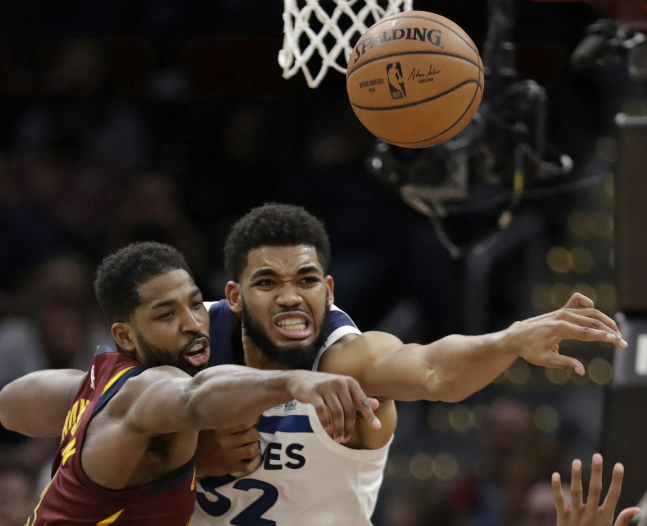 Cleveland Cavaliers' Tristan Thompson, left, and Minnesota Timberwolves' Karl-Anthony Towns battle for a loose ball in the second half of an NBA basketball game, Monday, Nov. 26, 2018, in Cleveland. The Timberwolves won 102-95. (AP Photo/Tony Dejak)