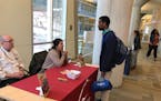 A teen speaks with recruiters from Kelber Catering, a local catering company, during the 13th annual Minneapolis Teen Job Fair on Saturday, April 21, 