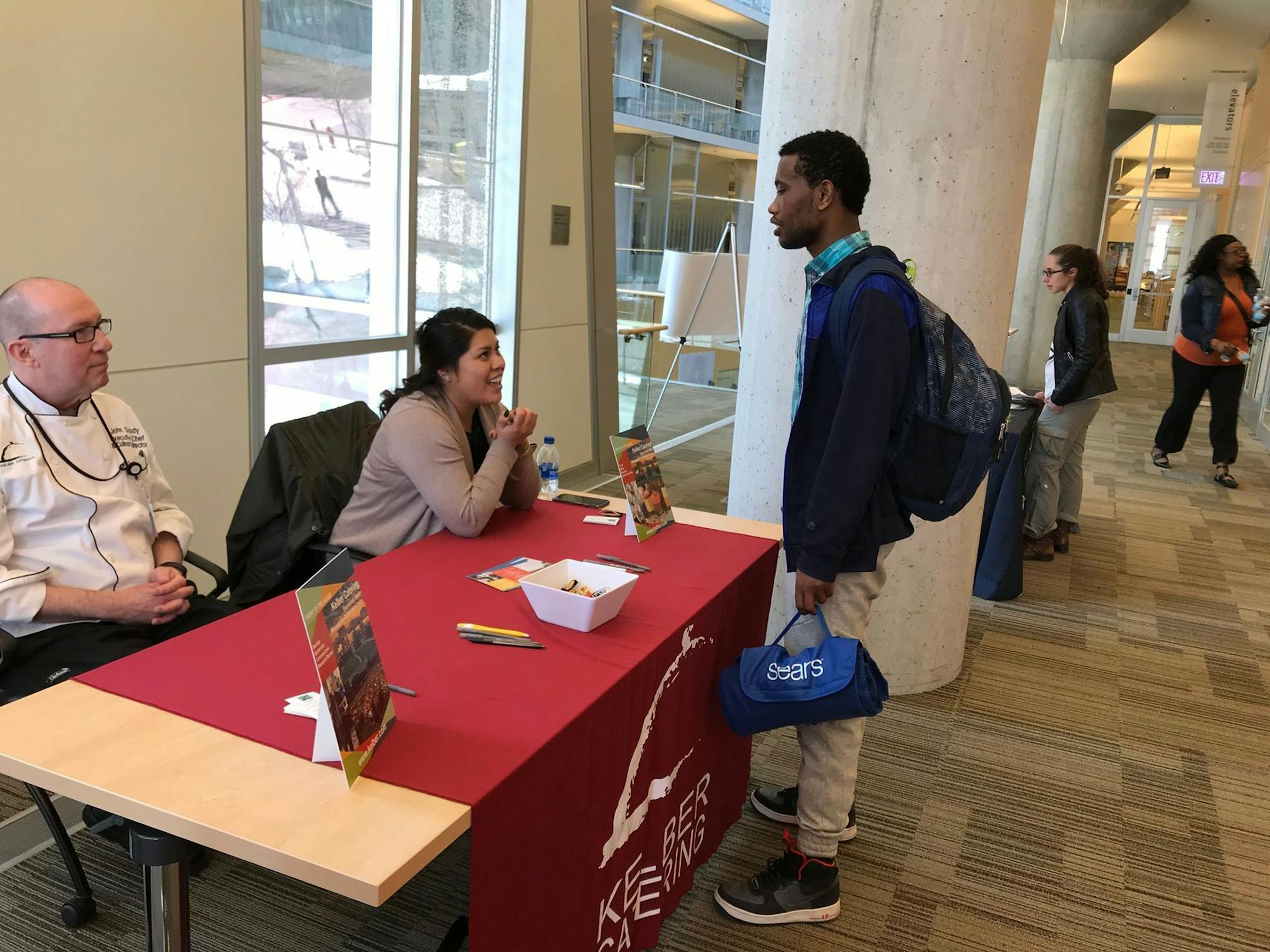 A teen speaks with recruiters from Kelber Catering, a local catering company, during the 13th annual Minneapolis Teen Job Fair on Saturday, April 21, 2018.