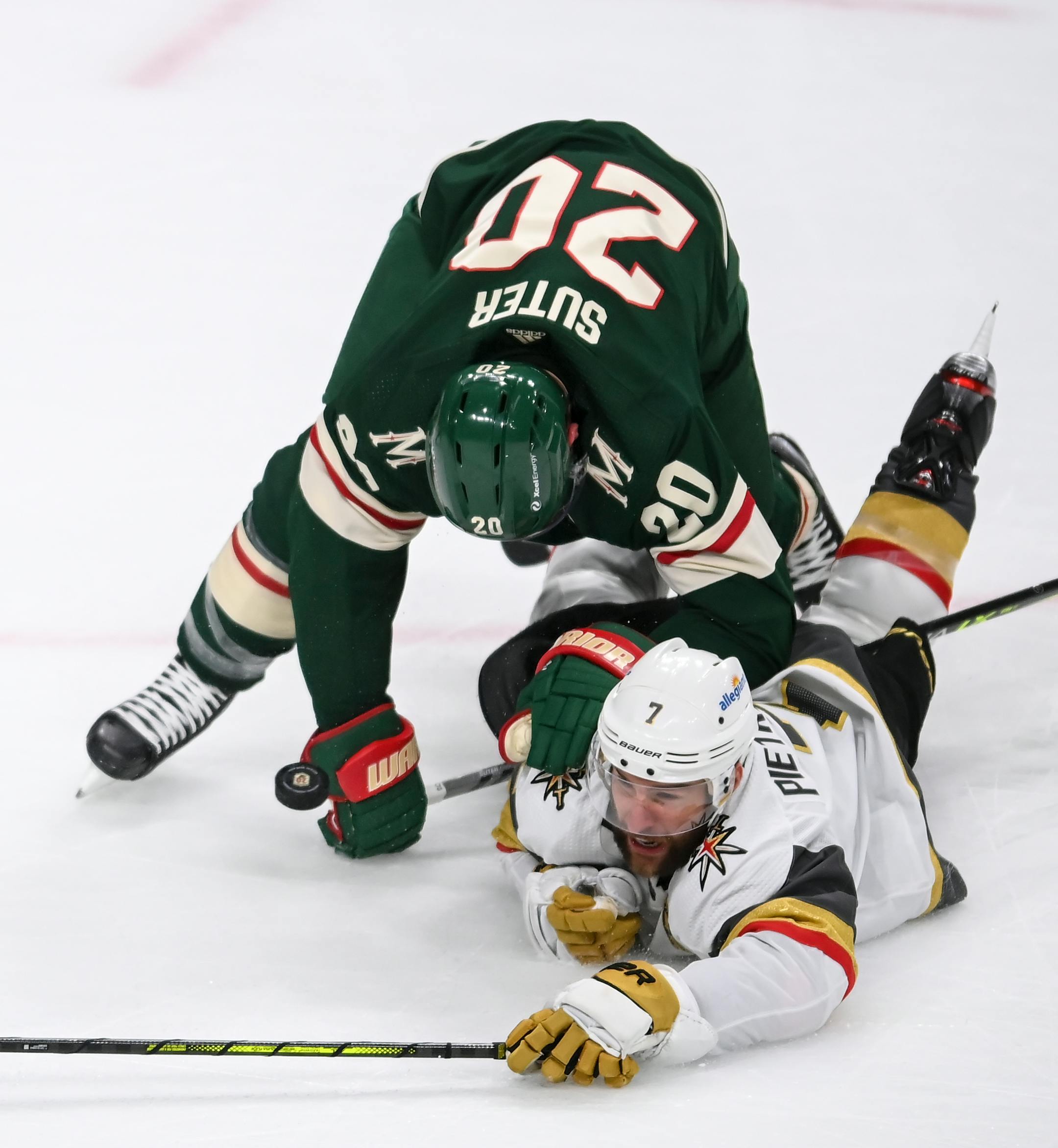 Vegas Golden Knights defenseman Alex Pietrangelo (7) fell to the ice chasing the puck as he was challenged by Minnesota Wild defenseman Ryan Suter (20) in the first period.