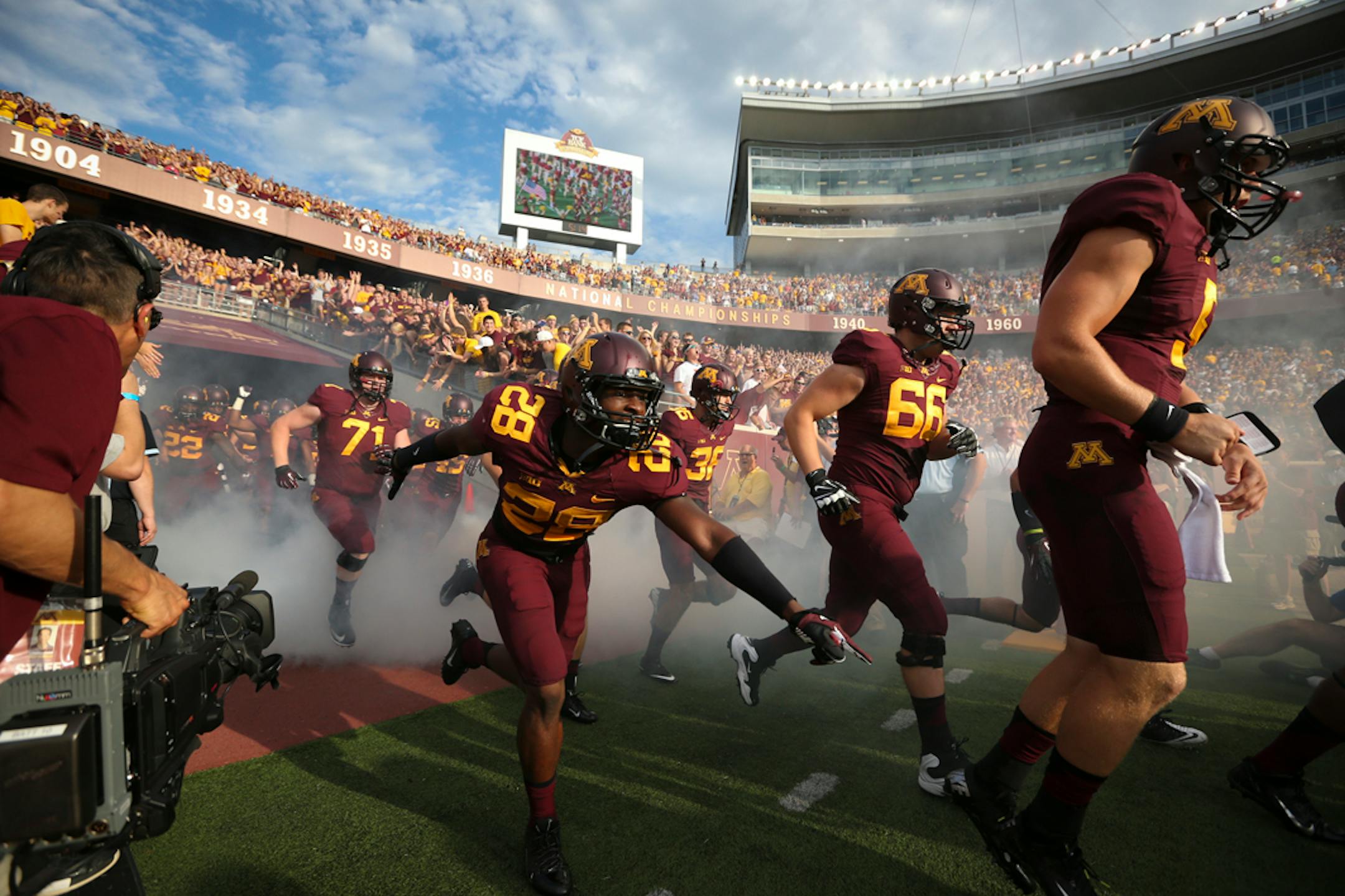 Players walked onto the field before the Minnesota Gophers vs. UNLV in the season opener at TCF Bank Stadium at the University of Minnesota in Minneapolis, Minn.