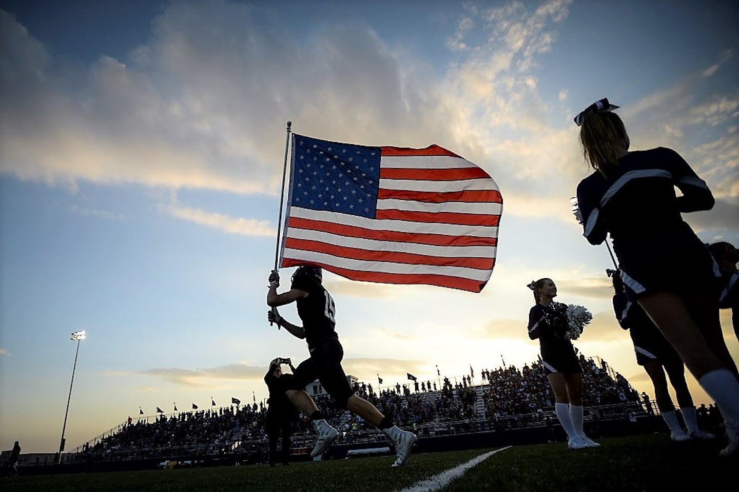 Buffalo defensive lineman Tucker Johnson (15) ran the US flag onto the field before the start of Friday night's game against Elk River. ] AARON LAVINSKY � aaron.lavinsky@startribune.com Elk River played Buffalo in a high school football game on Friday, Sept. 14, 2018 at Buffalo High School in Buffalo, Minn.