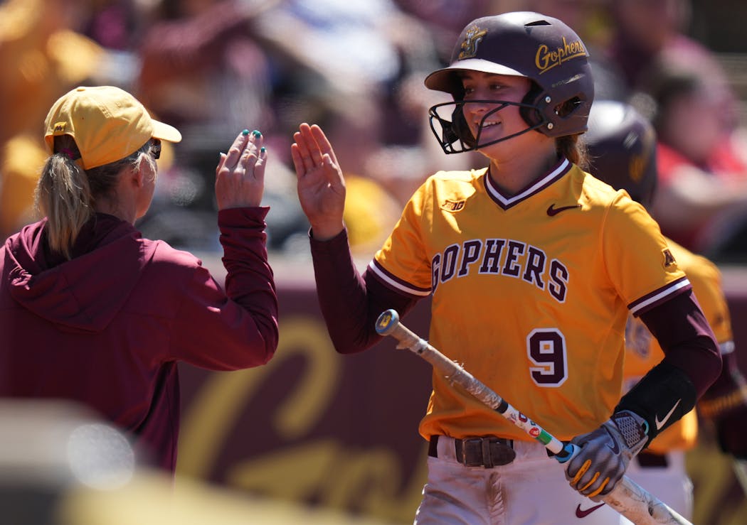 Gophers coach Piper Ritter high-fives shortstop Jess Oakland during Sunday's victory against Nebraska at Jane Sage Cowles Stadium.