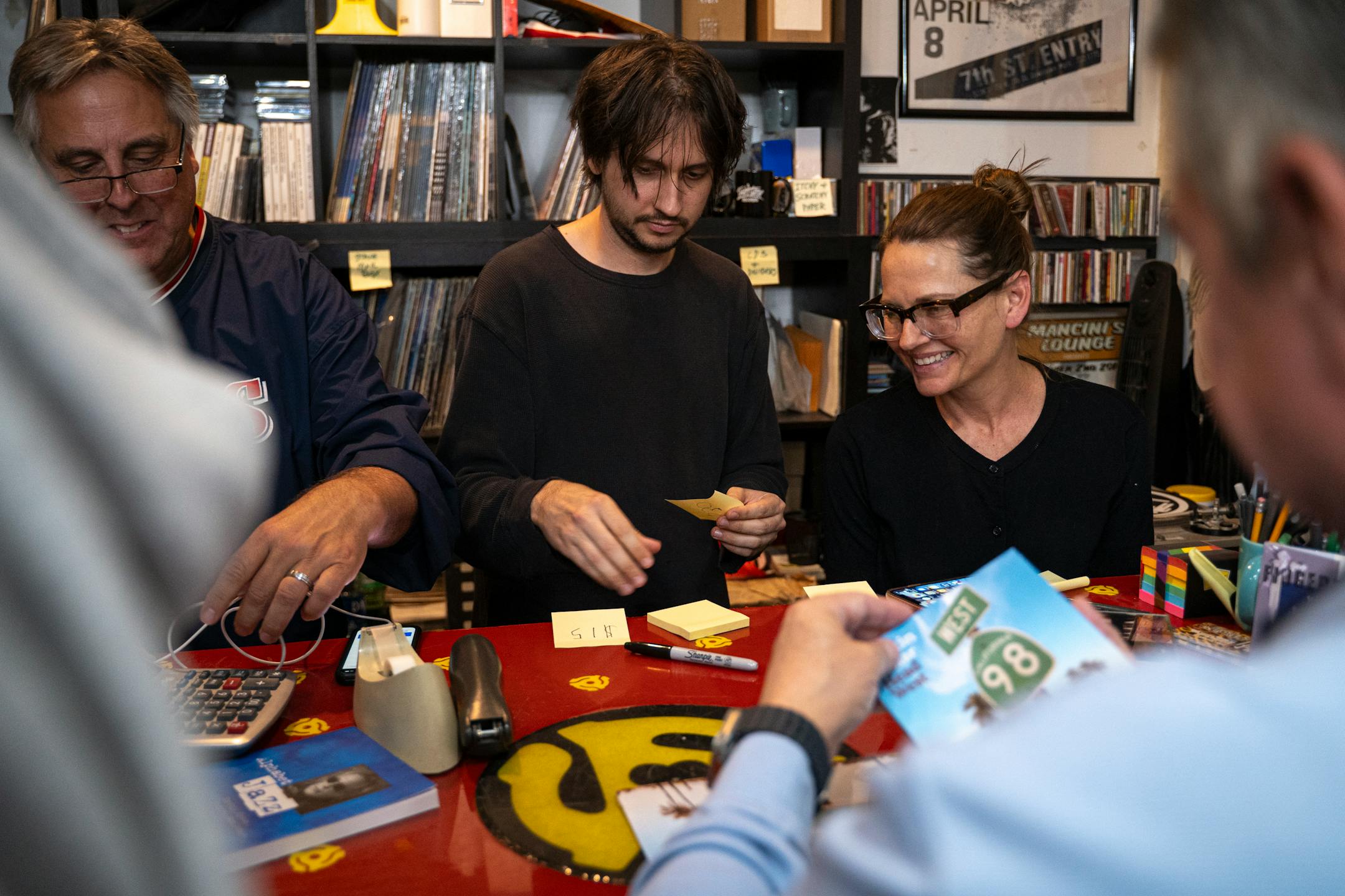 Dan Raden, Wilson Zellar and Carolyn Beaudot, Martin Zellar's wife, work the merchandise counter together at the Zellar family's album release party for "Head West" at HiFi Hair and Records in Minneapolis, Minn., on Thursday, Oct. 5, 2023. This is Martin Zellar's first solo album after an 11-year hiatus, thanks to Wilson, who played guitar on and produced the album. ] Angelina Katsanis • angelina.katsanis@startribune.com