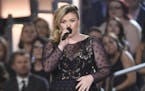 Kelly Clarkson presents the milestone award to Reba McEntire at the 50th annual Academy of Country Music Awards at AT&T Stadium on Sunday, April 19, 2