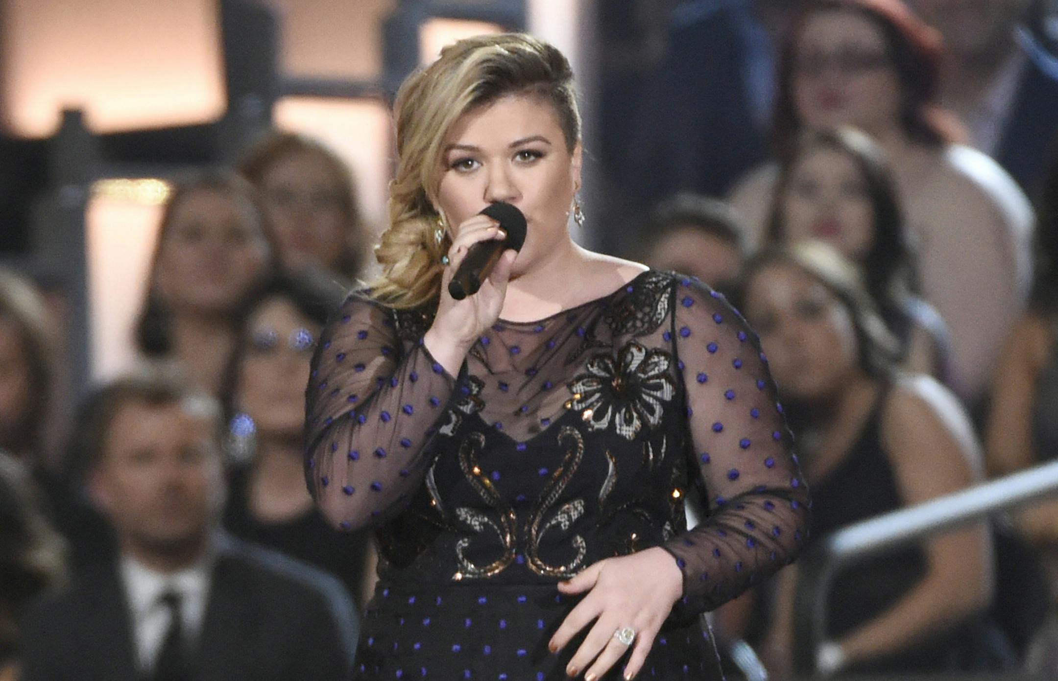 Kelly Clarkson presents the milestone award to Reba McEntire at the 50th annual Academy of Country Music Awards at AT&T Stadium on Sunday, April 19, 2015, in Arlington, Texas. (Photo by Chris Pizzello/Invision/AP) ORG XMIT: INVW