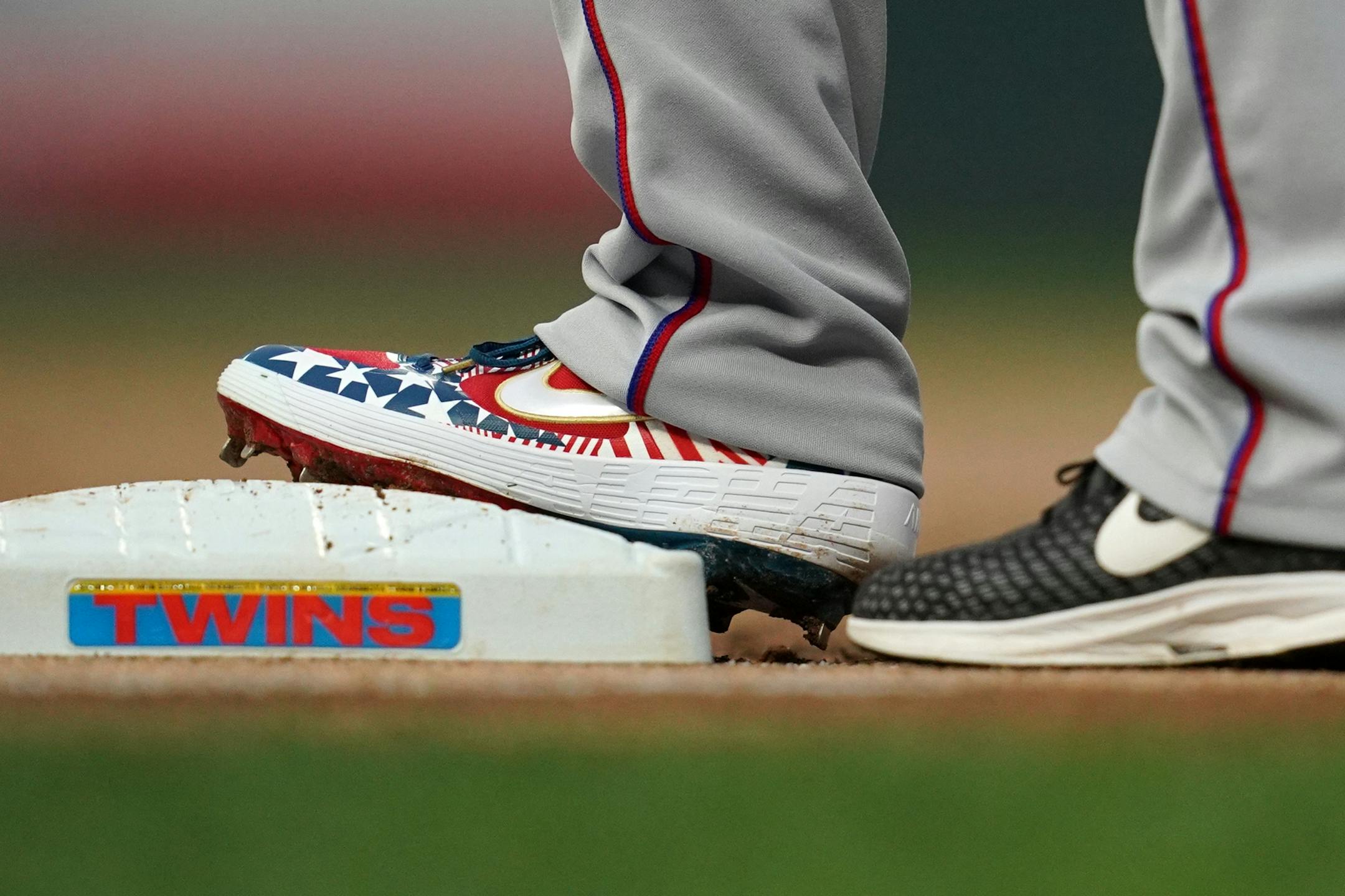 Texas Rangers shortstop Elvis Andrus (1) wore patriotic shoes as he stood on first after getting a base hit in the first inning.