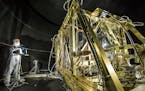 Dressed in a protective suit, NASA photographer Desiree Stover shines a light on a portion of the James Webb Space Telescope. Its infrared cameras wil